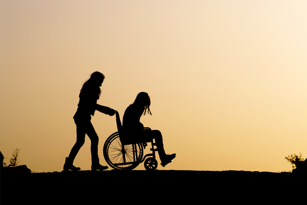 휠체어에 앉아 있는 여성과 끌어주는 여성 
