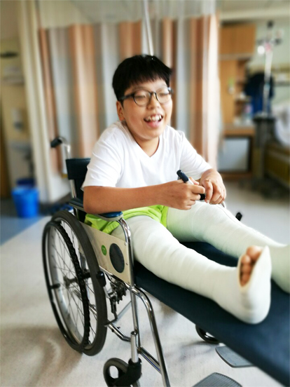 무릎 관절 수술 후 휠체어를 타고 있는 주언이(이주언 가족 제공)