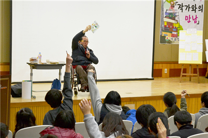 ▲ 서울 양원초등학교에서 ‘더불어 사는 세상을 위하여’라는 주제로 강연을 펼치는 고정욱 작가. 질문을 던지자 어린이들이 손을 번쩍 들고 있다. 뜨거운 환호와 열기로 가득하다.
