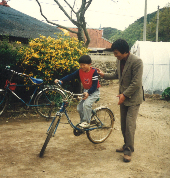아들에게 자전거를 가르쳐주는 황보태조 기부자