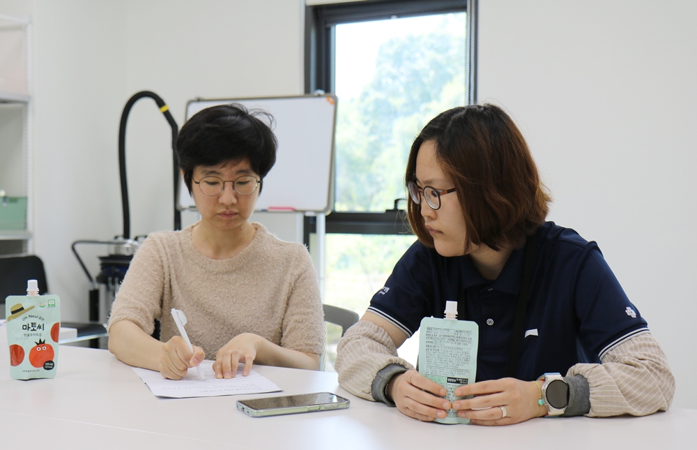 김유리 작가(왼쪽)의 기록을 바라보는 육서정 직원의 모습