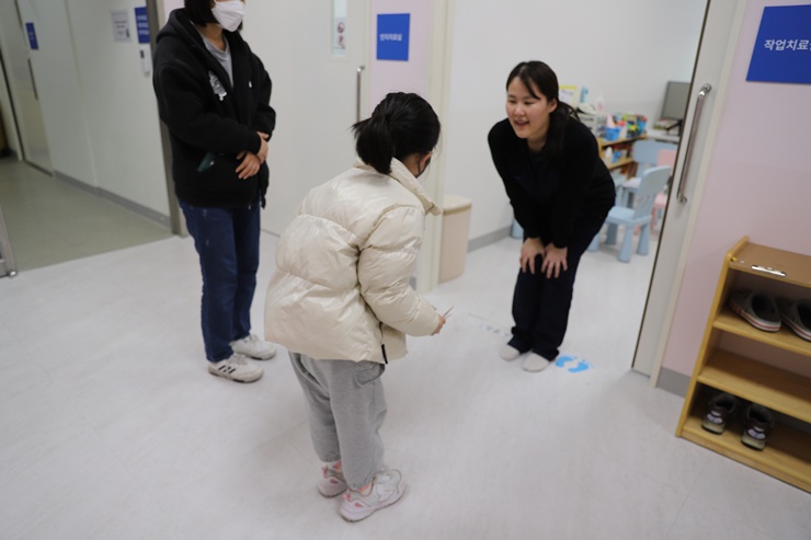 치료 후 치료사 선생님과 눈을 맞추며 인사하는 정하