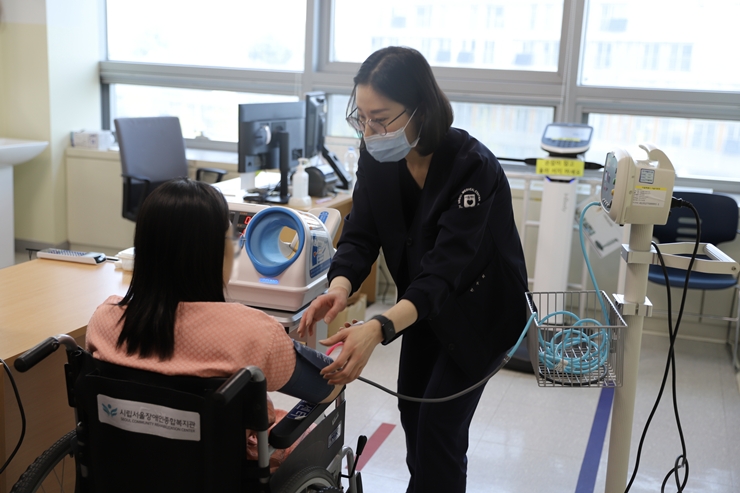 휠체어에 앉아 기초검사를 받고 있는 장애인 모습