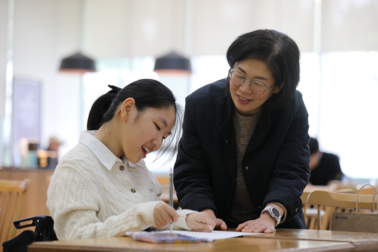 푸르메어린이재활병원 로비에서 엄마와 함께 그림을 그리는 은영이